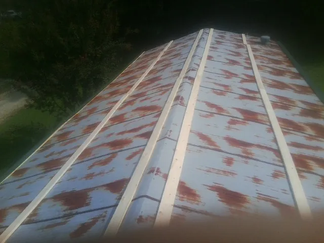 Rusted metal roof panels with new wood purlins before replacement — Storm Damage Roof Repair in Langsville by Roofing Brothers