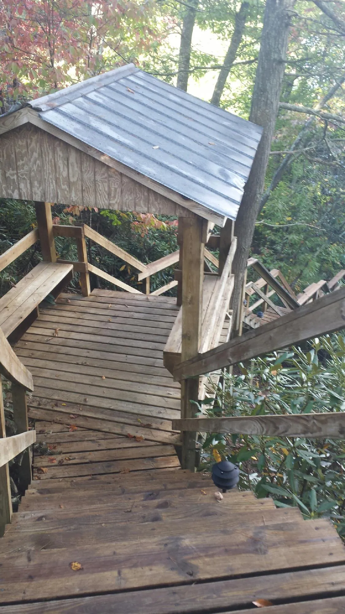 Metal roofed shelter over wooden steps on a wooded walkway — Skylight Repair & Installation work by our crew in Langsville