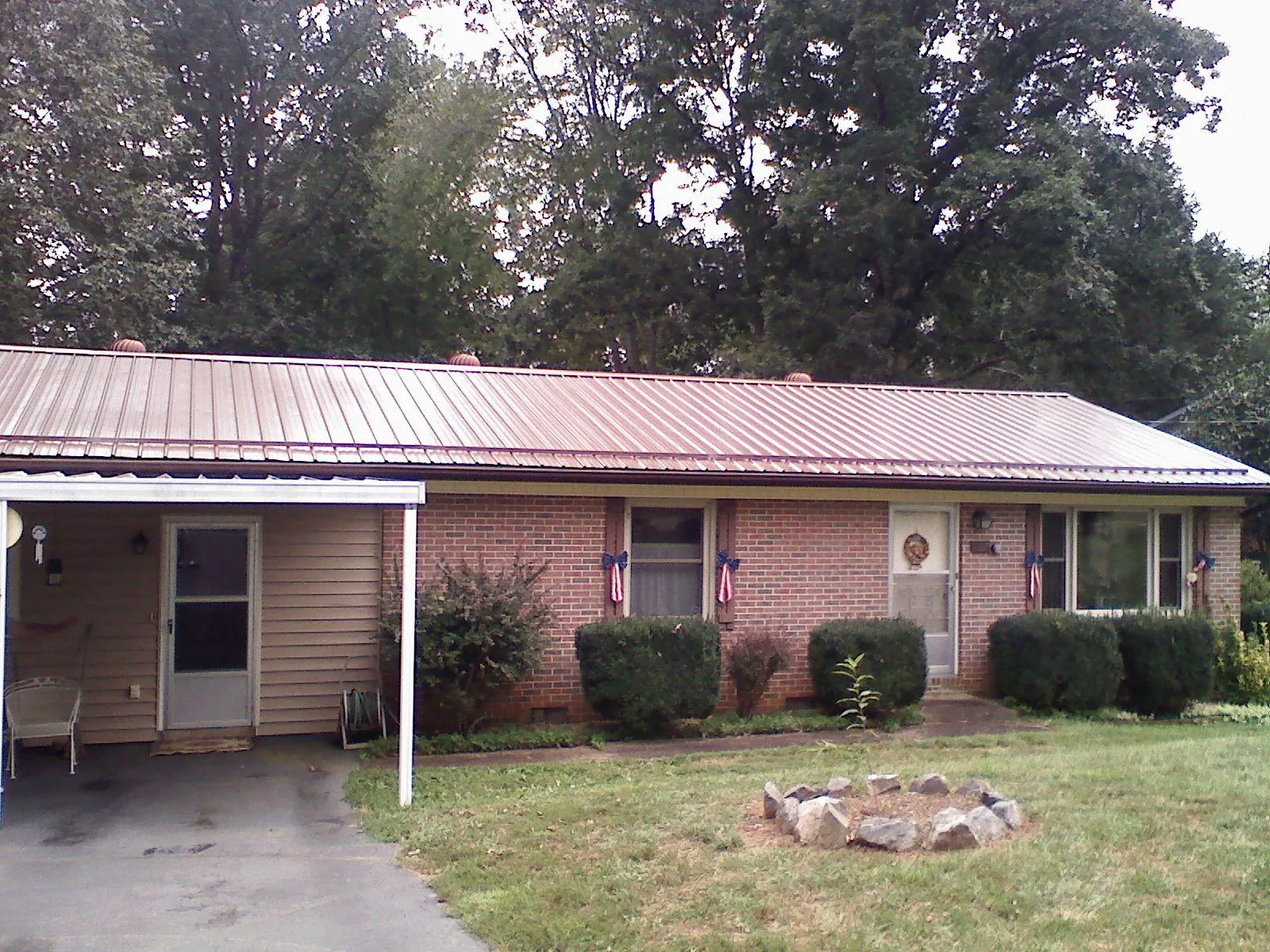 Bronze metal roof and carport on a brick ranch home — Roof Repair work by our crew in Langsville